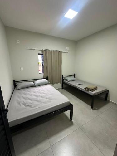 a bedroom with two beds and a window at Center in Uberlândia