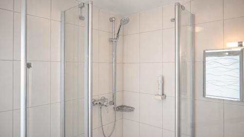 a bathroom with a shower with a glass door at Hotel Leitner in Kaufbeuren