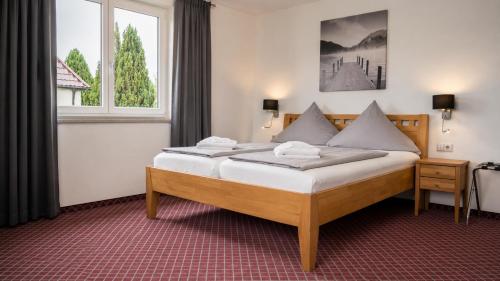 a bedroom with a large bed in front of a window at Hotel Leitner in Kaufbeuren
