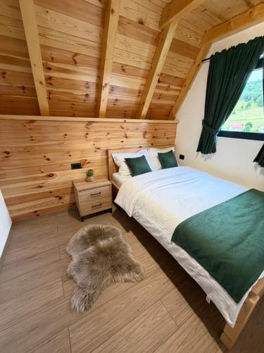 a bedroom with a bed and a rug at V Chalet in Žabljak