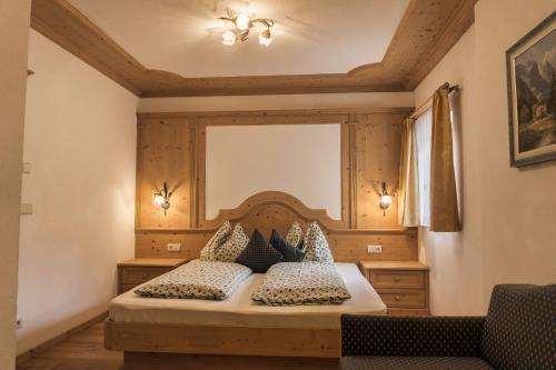 a bedroom with a bed with a wooden headboard at Apartments Ciastel in San Vigilio Di Marebbe