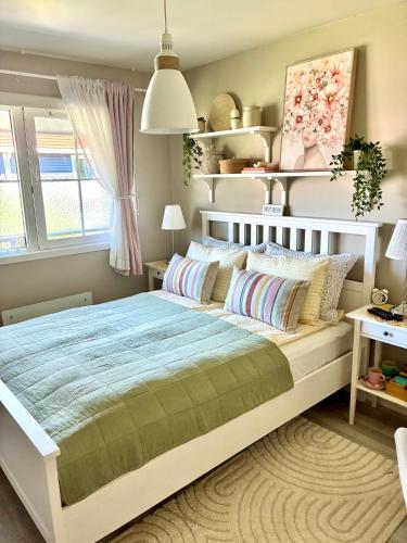 a bedroom with a large white bed and a window at Home between flights Gardermoen in Jessheim