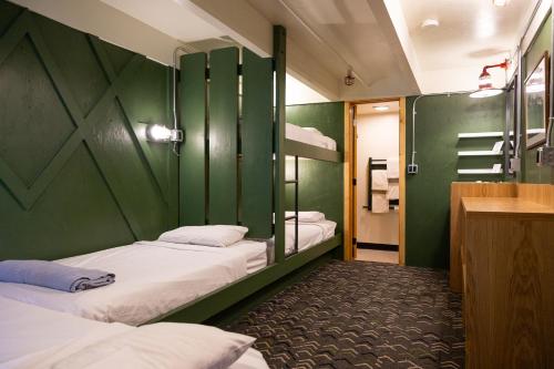 a room with three bunk beds and a bathroom at The Hostel in Teton Village
