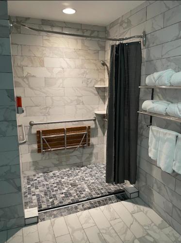 a bathroom with a shower with a stone wall at The Inn at Canaan in Davis