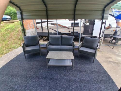 a group of chairs and a table in front of a rv at Camper with Queen and bunk bed in Robbinsville