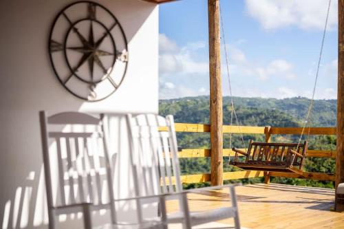 a couple of chairs on a porch with a view at Casa Brisa with Heated Pool Mountain View & River in Las Marias