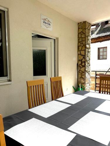 a room with a table and two chairs and a door at Fehér Villa in Kővágóörs
