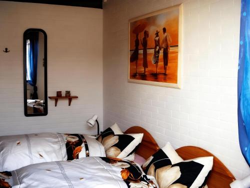 a bedroom with two beds with pillows and a painting at Nordseeferienbungalow in Butjadingen