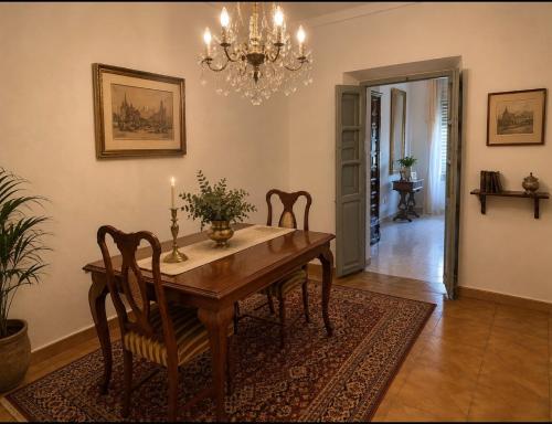 a dining room with a table and chairs and a chandelier at Casa Abuela Dolores in Setenil
