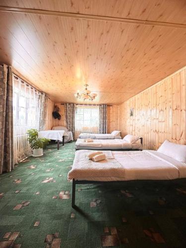 a bedroom with four beds in a room at NURDAN Guest House Barskoon in Barskoon