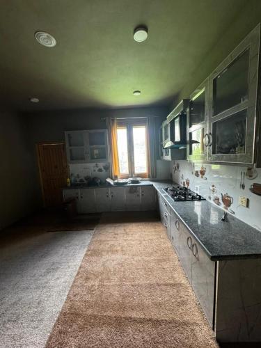 a large kitchen with a counter and a window at Marvoi resort in Hunza Valley