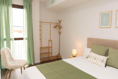 a bedroom with a bed and a chair and a window at Xena Abeto by BeValle in Panticosa