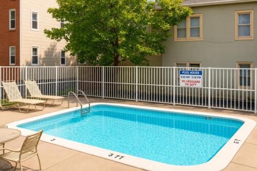 a swimming pool with chairs and a fence at Boardwalk One in Ocean City