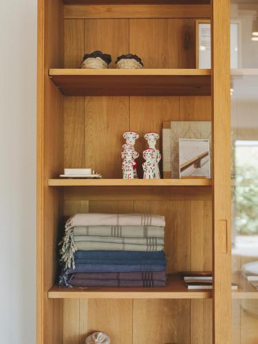 a wooden book shelf with towels and vases on it at Hotel Es Blau Des Nord in Colonia de Sant Pere