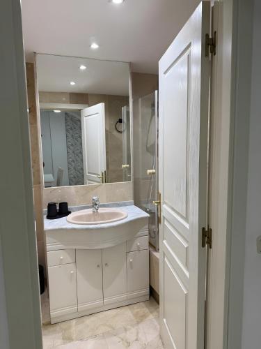 a white bathroom with a sink and a mirror at Gilarez in Estepona