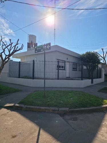a white building with a fence and a street sign at Soles de Pergamino in Pergamino