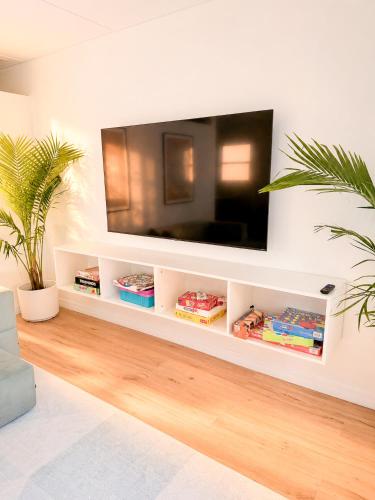 a living room with a television on a wall at Tropical Luxe Villa-Near Airport, Minutes to Lido key beach, Downtown and Dining in Sarasota