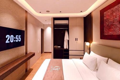 a bedroom with a bed and a clock on the wall at The Pathway Sầm Sơn in Sầm Sơn