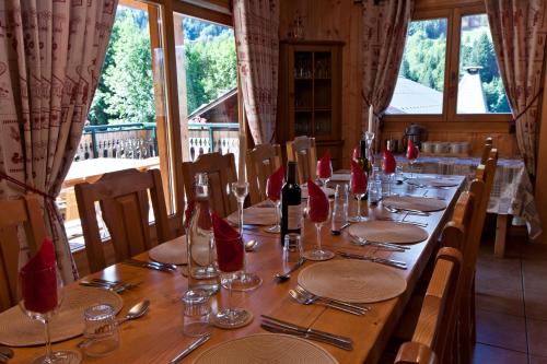 a long wooden table with red napkins and wine glasses at Riders Refuge - Chalet Eterle in Morzine