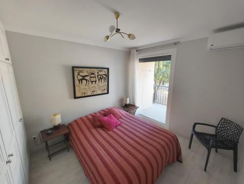 a bedroom with a bed with a pink blanket at T4 proche de la plage & du centre in LʼÎle-Rousse