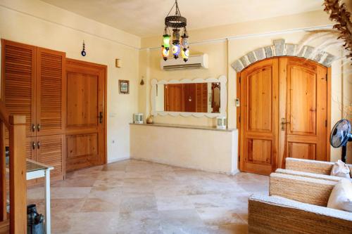 a living room with wooden doors and tile floors at Villa Mandarin by Important Group Travel in Bitez