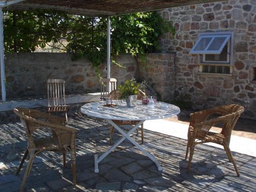 einen Tisch und Stühle auf einer Terrasse mit Sonnenschirm in der Unterkunft To Spitaki House in Perdika