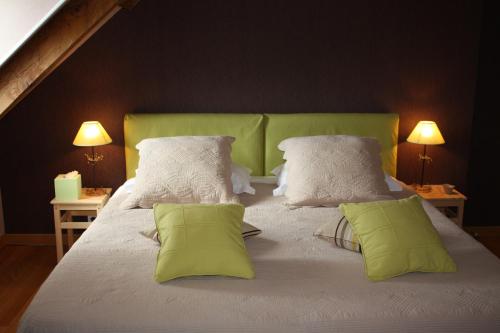 a bedroom with a large bed with green headboard and pillows at Le Clos Près Chambord in Maslives