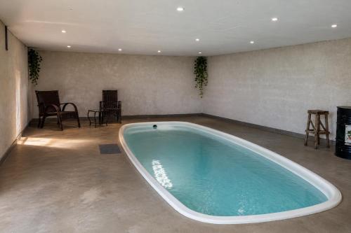 a large tub in a room with chairs and a table at Pousada Sítio Xodó in Santana do Riacho