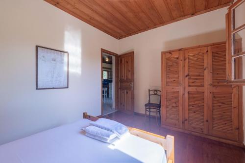 a bedroom with a bed and a wooden ceiling at Zanteva-Cottages in Vasilikos