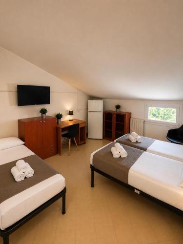 a hotel room with two beds and a flat screen tv at Rubiera Residence - H24 in Zimella