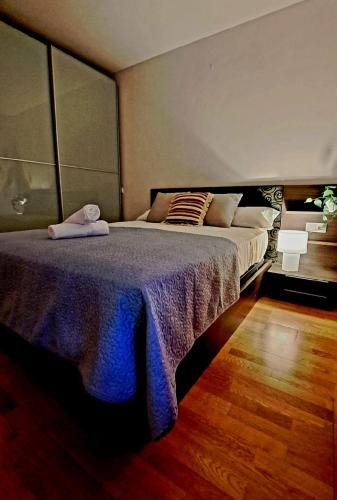 a bedroom with a large bed with a purple blanket at LUMARE LUANCO - A 5 min de la playa a pie - Parking incluido in Luanco