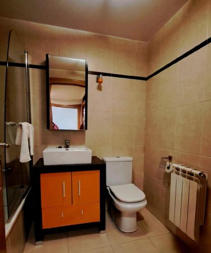a bathroom with a toilet and a sink and a mirror at LUMARE LUANCO - A 5 min de la playa a pie - Parking incluido in Luanco