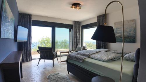 a bedroom with a bed and a desk and a balcony at Villa Adria Heights in Pečurice