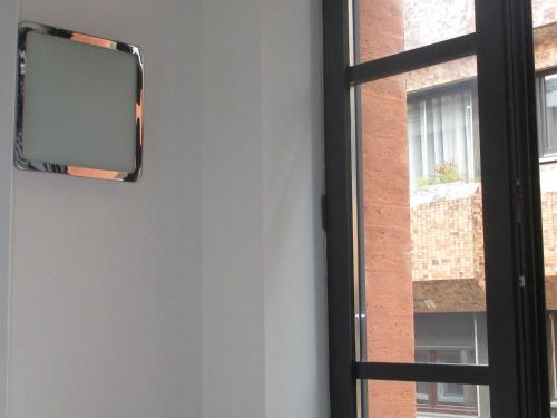 a mirror on a wall next to a window at Hôtel le Pastel in Toulouse