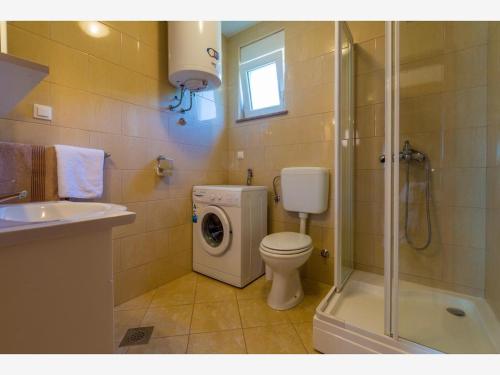 a bathroom with a toilet and a washing machine at Apartment Ivana in Crikvenica