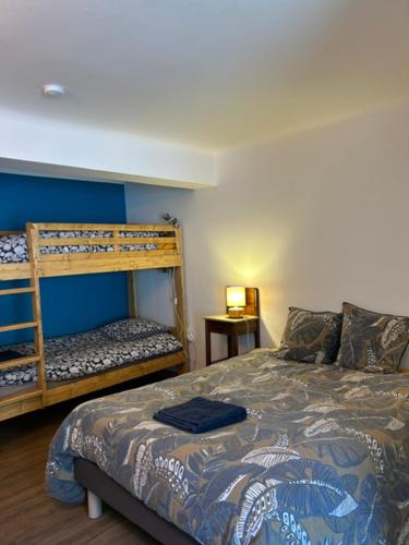 a bedroom with a bed and a bunk bed at Chambres d'hôtes de l'encabanée in Saint-Paul