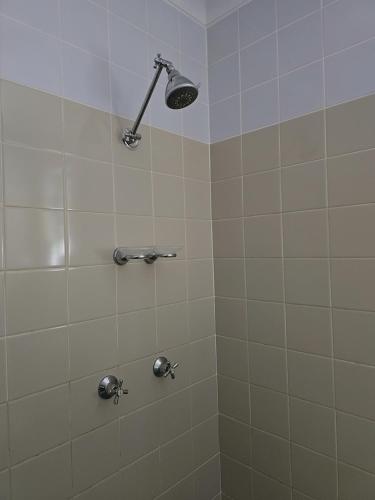 a shower with a shower head in a bathroom at Bramston beach resort in Bramston Beach