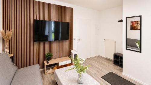 a living room with a couch and a tv on a wall at Gartenparadies mit Rheinblick in Urbar in Urbar