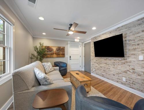 a living room with a couch and a tv on a brick wall at Carters Court Serene Suite in Franklin