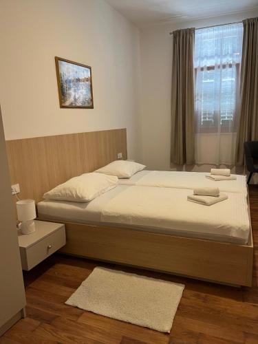 a bedroom with a bed and a window at Hotel Park Drniš in Drniš