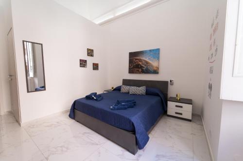 a bedroom with a blue bed in a white room at Sogno Di Mezzanotte in Taranto