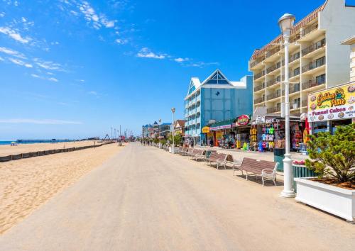 a beach with chairs and buildings and the ocean at Boardwalk One in Ocean City