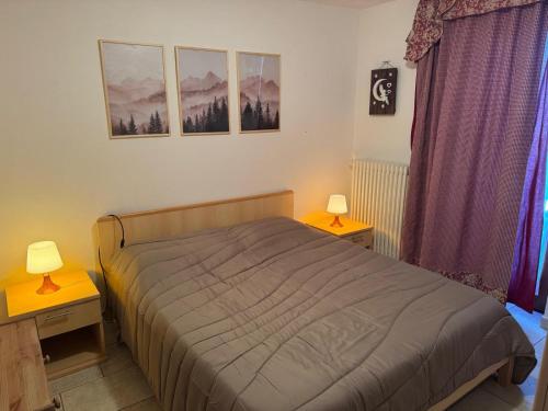 ein Schlafzimmer mit einem Bett und zwei Lampen auf Tischen in der Unterkunft Maison Biula in Cerise