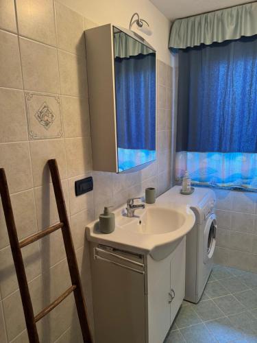 ein Badezimmer mit Waschbecken und Waschmaschine in der Unterkunft Maison Biula in Cerise