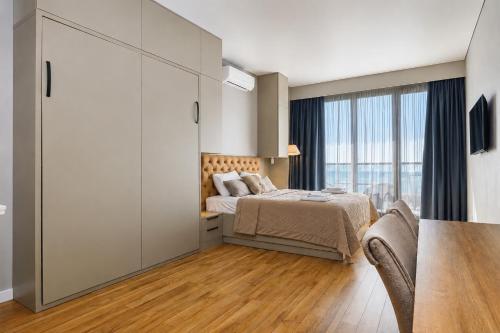 a bedroom with a bed and a large window at Mayak Bamboo Beach Apartments in Kobuleti