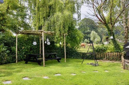 a park with a picnic table and swings in the grass at Weidezicht in Ermelo