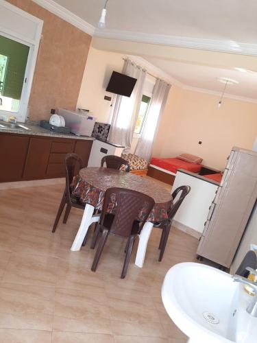 a kitchen and dining room with a table and chairs at Résidence Nydia in Ras El Ma