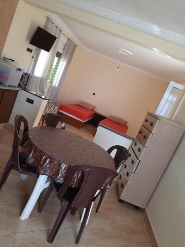 a room with a table and chairs and a kitchen at Résidence Nydia in Ras El Ma