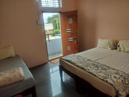 a bedroom with a bed and a door to a balcony at Swarna Lodge in Badami