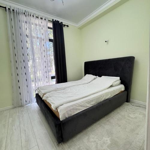 a bed in a bedroom with a large window at Атлантис in Chon-Sary-Oy